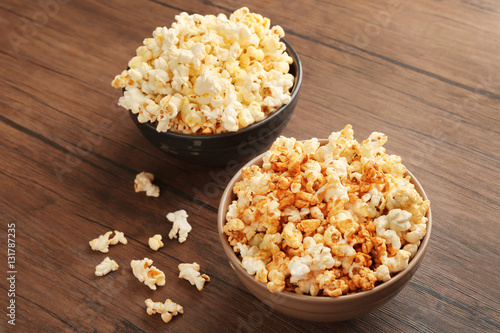 Popcorn in bowls on wooden background