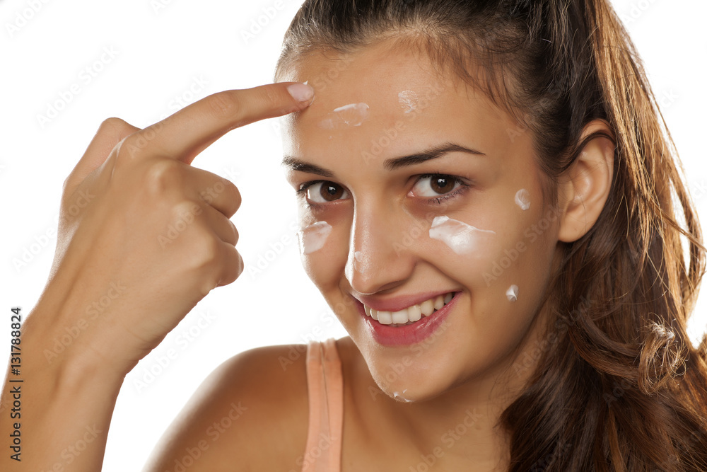young beautiful woman applied protective cream on her face young beautiful woman applied protective cream on her face