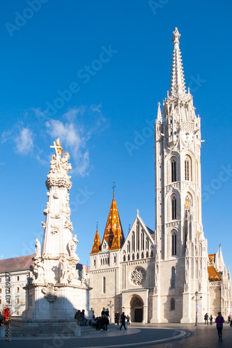 Roman Catholic Matthias Church and Holy Trinity plaque column at Fisherman's Bastion in Buda Castle District, Budapest, Hungary, Europe. Sunny day shot with clear blue sky.