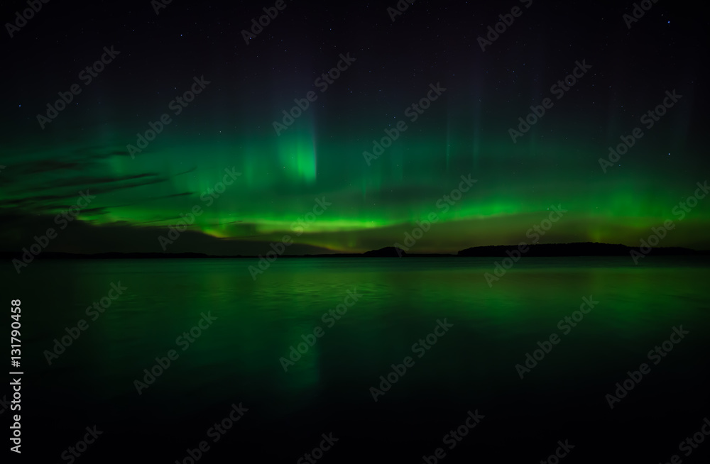 Northern lights dancing over calm lake