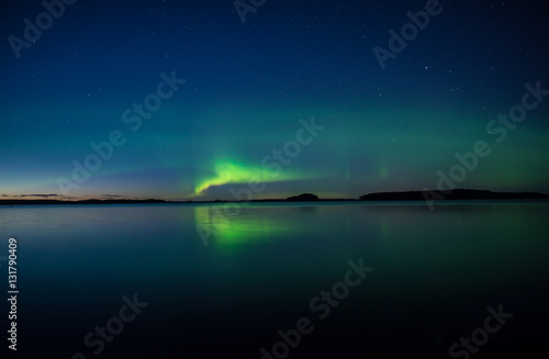 Northern lights dancing over calm lake