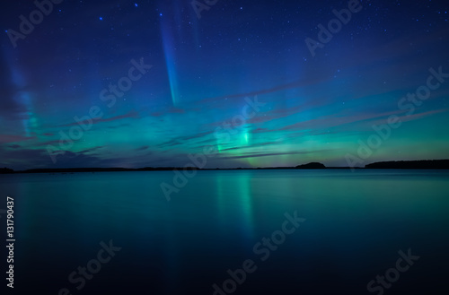 Northern lights dancing over calm lake