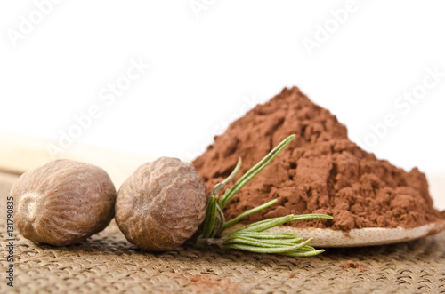 nutmeg with a sprig of rosemary and cacao powder