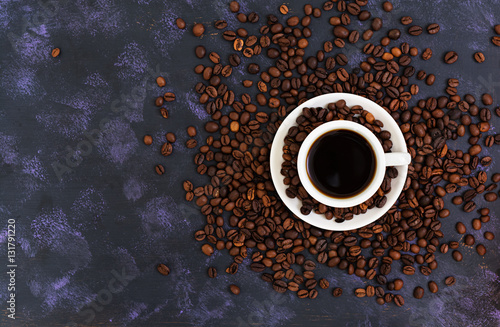 Coffee cup and coffee beans on dark background. Top view. Flat lay