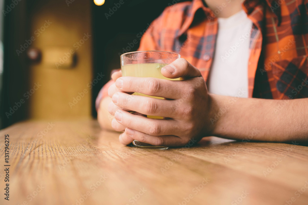 Young student is sitting in the restaurant and taste a warm drink. man drinking  tea at the cafe