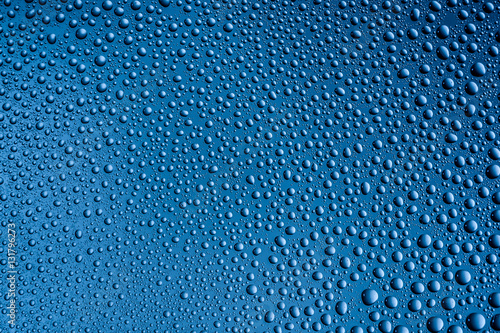 misted glass with drops water on a blue background