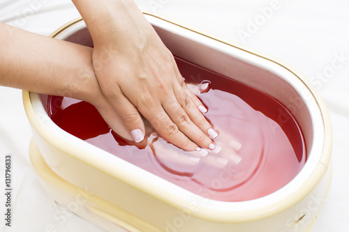 Process paraffin treatment of female hands in beauty salon