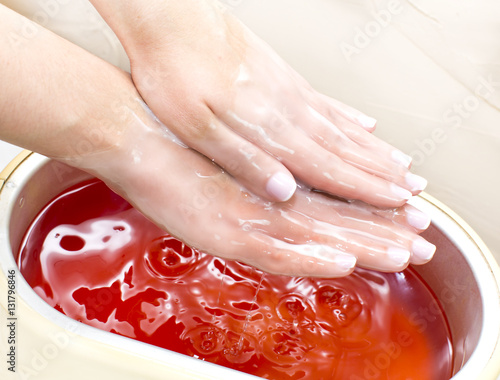 Process paraffin treatment of female hands in beauty salon