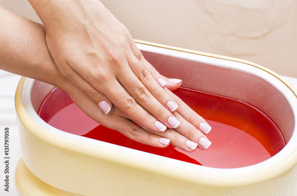 Ταπετσαρία Process paraffin treatment of female hands in beauty salon