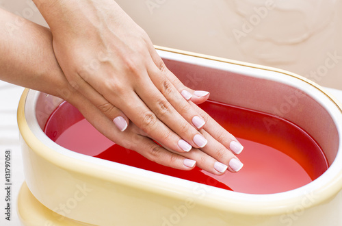 Fototapeta Process paraffin treatment of female hands in beauty salon