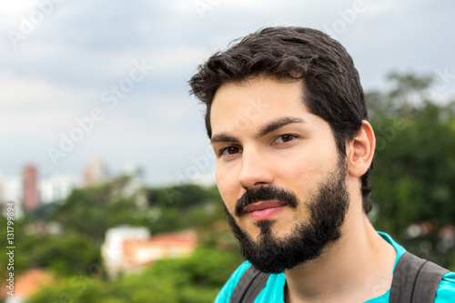 Young man with beard looking at camera