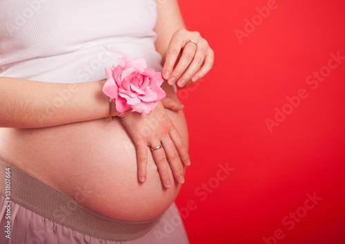 Image of pregnant woman touching her belly with hands