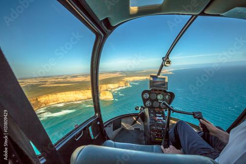 Closeup of the helicopter cockpit, during scenic flight over the Great Ocean Road in Victoria, Australia in the Port Campbell National Park flying over the Twelve Apostles and the shipwreck coast