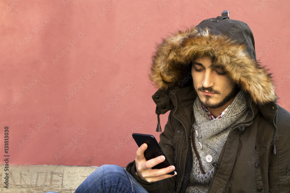 Fototapeta premium young man sitting with mobile phone