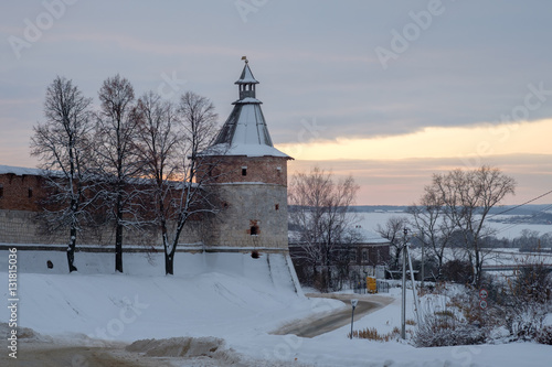 Зимний пейзаж с видом башни старинного кремля в русском городе Зарайске на фоне заката 