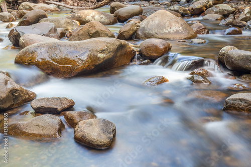 Natural rocks over the flowing clear water.