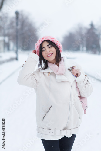 Beautiful young woman wearing merino wool pastel colors hat morning outdoors. Skin Care, Lip care, care of the eyelashes in the winter season. Beauty young woman Having Fun in Winter Park.