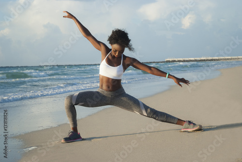 Young woman stretching on beach