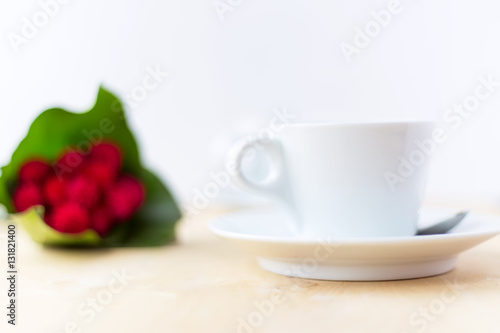 Cup with coffee, flower on wooden table in morning time