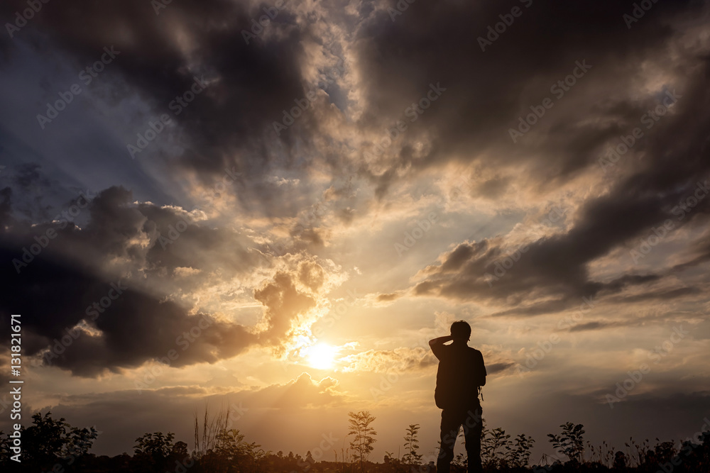 Silhouette man with backpack use smartphone in hands at sunset b Silhouette man with backpack use smartphone in hands at sunset b