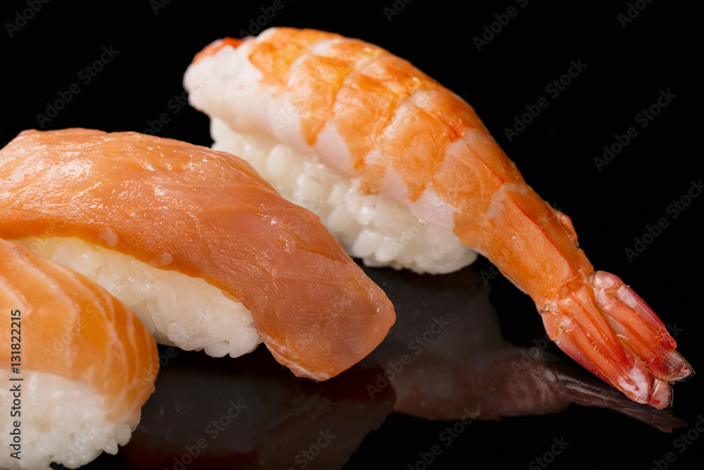 Sushi nigiri with shrimp and salmon sushi on black background with reflection. Japanese cuisine Sushi nigiri with shrimp and salmon sushi on black background with reflection. Japanese cuisine