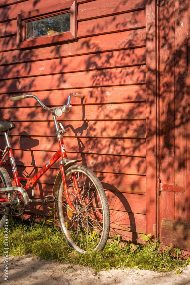 Old bicycle leaning against grungy barn. Old classic bicycle parked in front of wood plank barn wall.