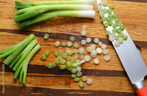 Sliced, chopped spring onions, salad onions, green onions or scallions on wood background