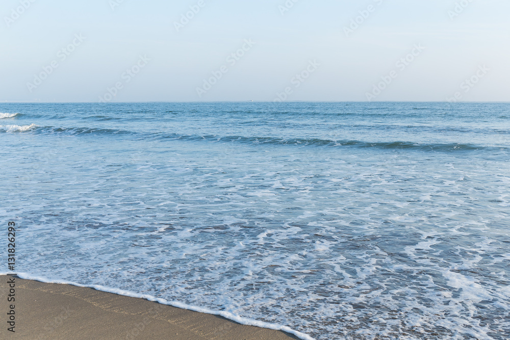 Obraz premium Blue ocean on sandy beach