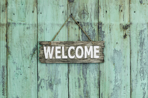 Welcome sign hanging on rustic wood background
