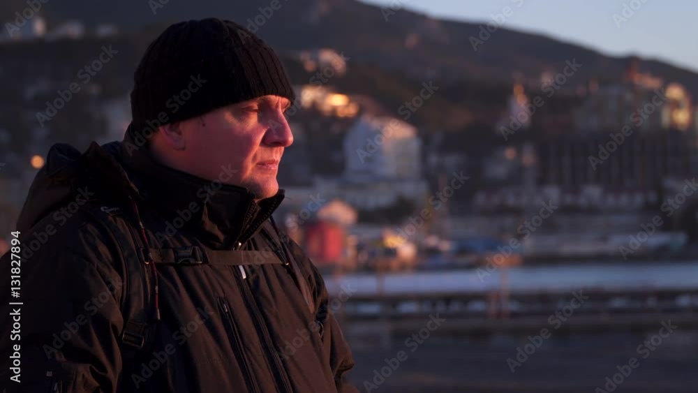 Portrait of a man whose face was lit by the rising sun. In the background the outline of the mountains Portrait of a man whose face was lit by the rising sun. In the background the outline of the mountains