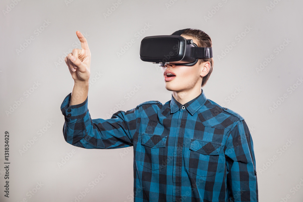emotional funny man wearing virtual reality goggles. Studio portrait of video game designer wearing VR headset. studio shot isolated on gray background. emotional funny man wearing virtual reality goggles. Studio portrait of video game designer wearing VR headset. studio shot isolated on gray background.