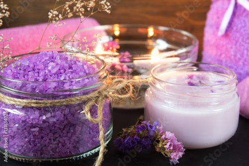 Spa products. Lavender bath salts  dry flowers  cosmetic cream  light candles and towel. Violet purple concept. Coloring and processing photo.