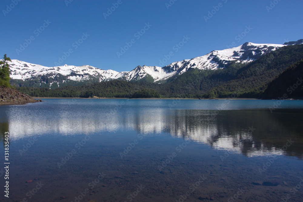 Reflection of the snow-covered mountains in the lake in the Conguillío National Park in Chile