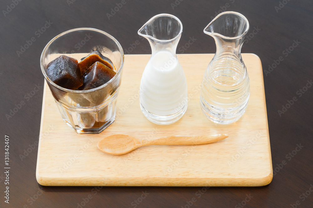 Ice coffee in ice-cube shape with steam milk and syrup on wooden Ice coffee in ice-cube shape with steam milk and syrup on wooden