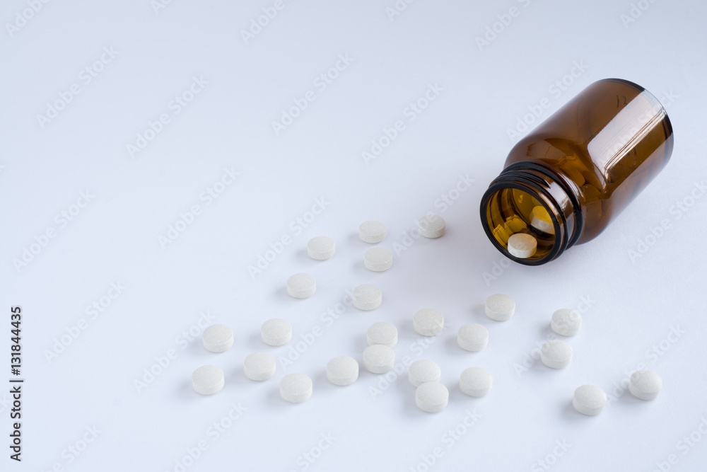 White pills and brown glass bottle White pills and brown glass bottle