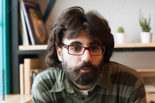 A photo a bearded man wearing glasses