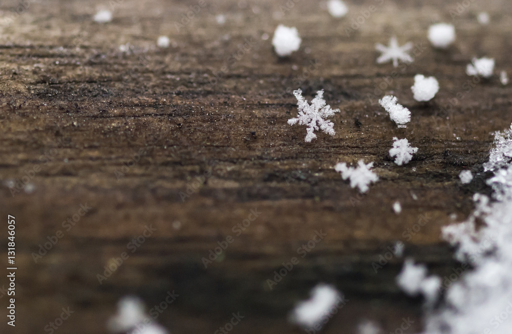Individual real snowflakes on a frozen rustic wood background Individual real snowflakes on a frozen rustic wood background