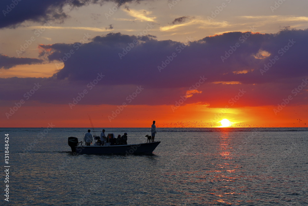 Fishermen and dog on a boat at sunset - Florida