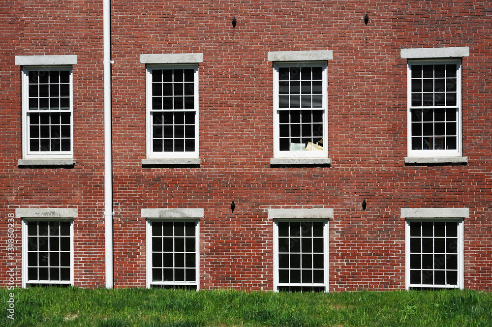 close up on old brick wall building and green lawn