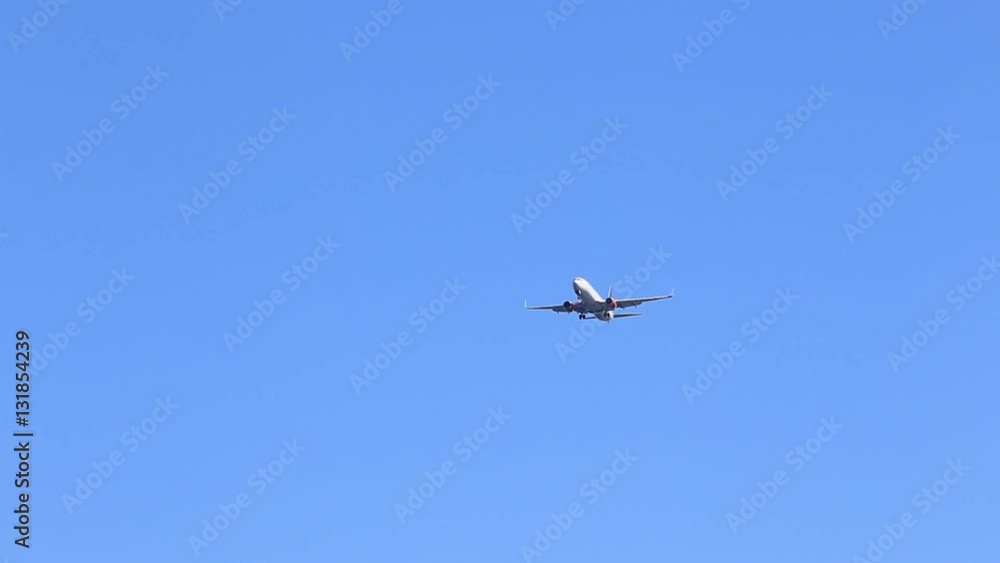Commercial airline plane flying by overhead on sunny, blue sky day. Commercial airline plane flying by overhead on sunny, blue sky day.