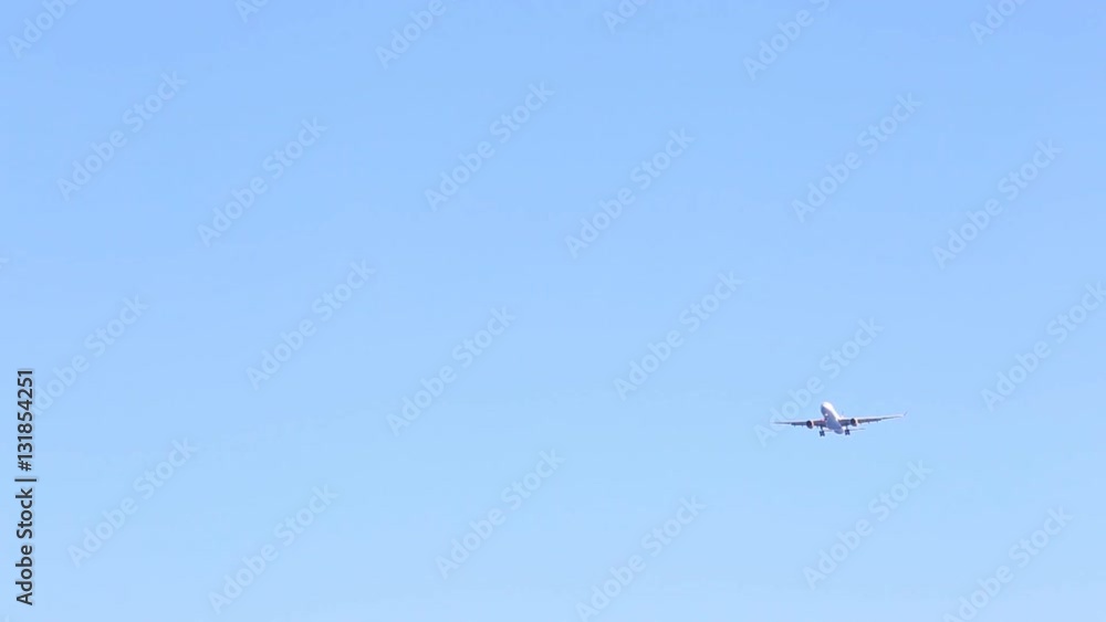 Jet plane approaching landing across blue sky Jet plane approaching landing across blue sky
