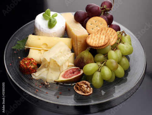 Cheese platter with different cheese and grapes 