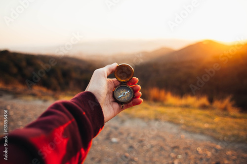 Hand of person holding compass photo