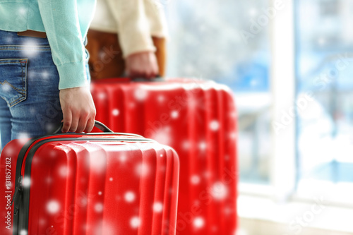Winter vacation concept. Snowy effect on background. Couple with luggage