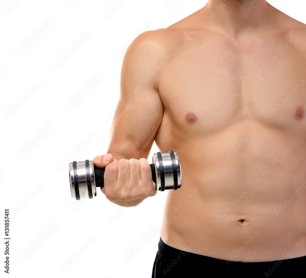 Young man doing exercises with dumb-bells indoors