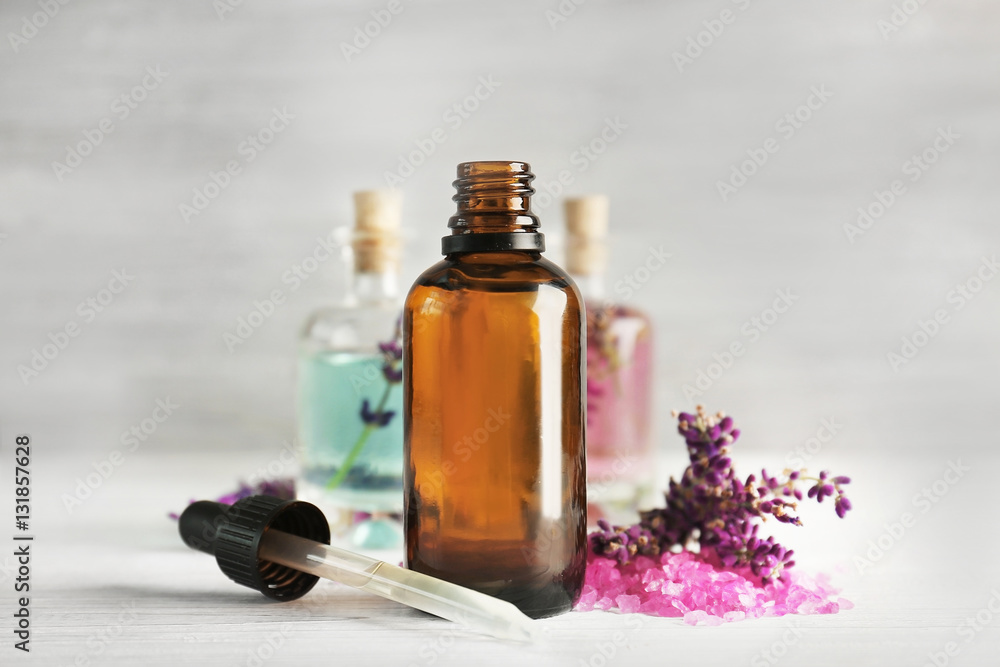 Bottles with lavender oil and flowers on wooden background Bottles with lavender oil and flowers on wooden background