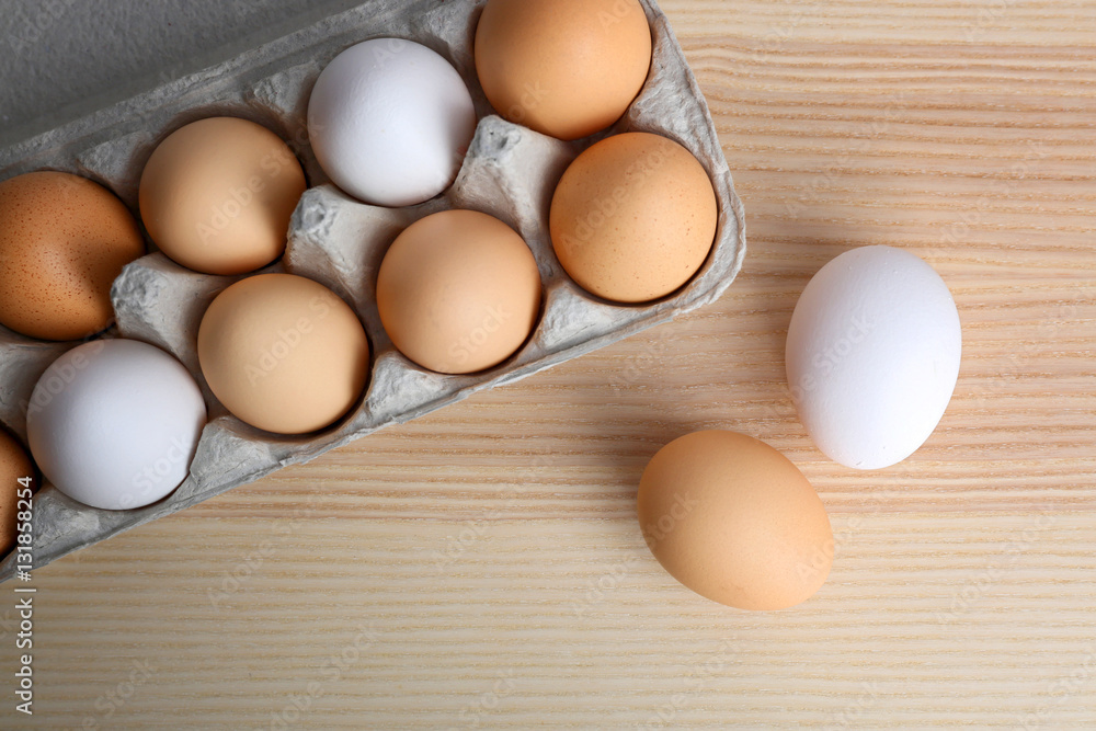 Raw eggs in package on wooden table Raw eggs in package on wooden table