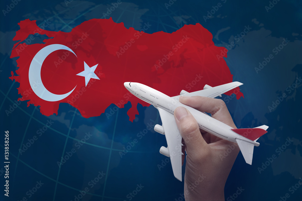 hand holding airplane with map of Turkey.