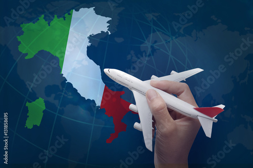 hand holding airplane with map of Italy.
