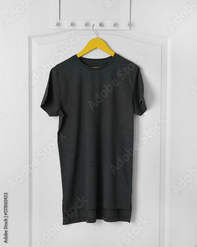 Blank black t-shirt hanging on white door